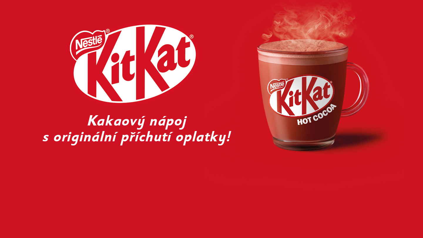 Horký kakaový nápoj KitKat v červeném hrnku, pára stoupá.